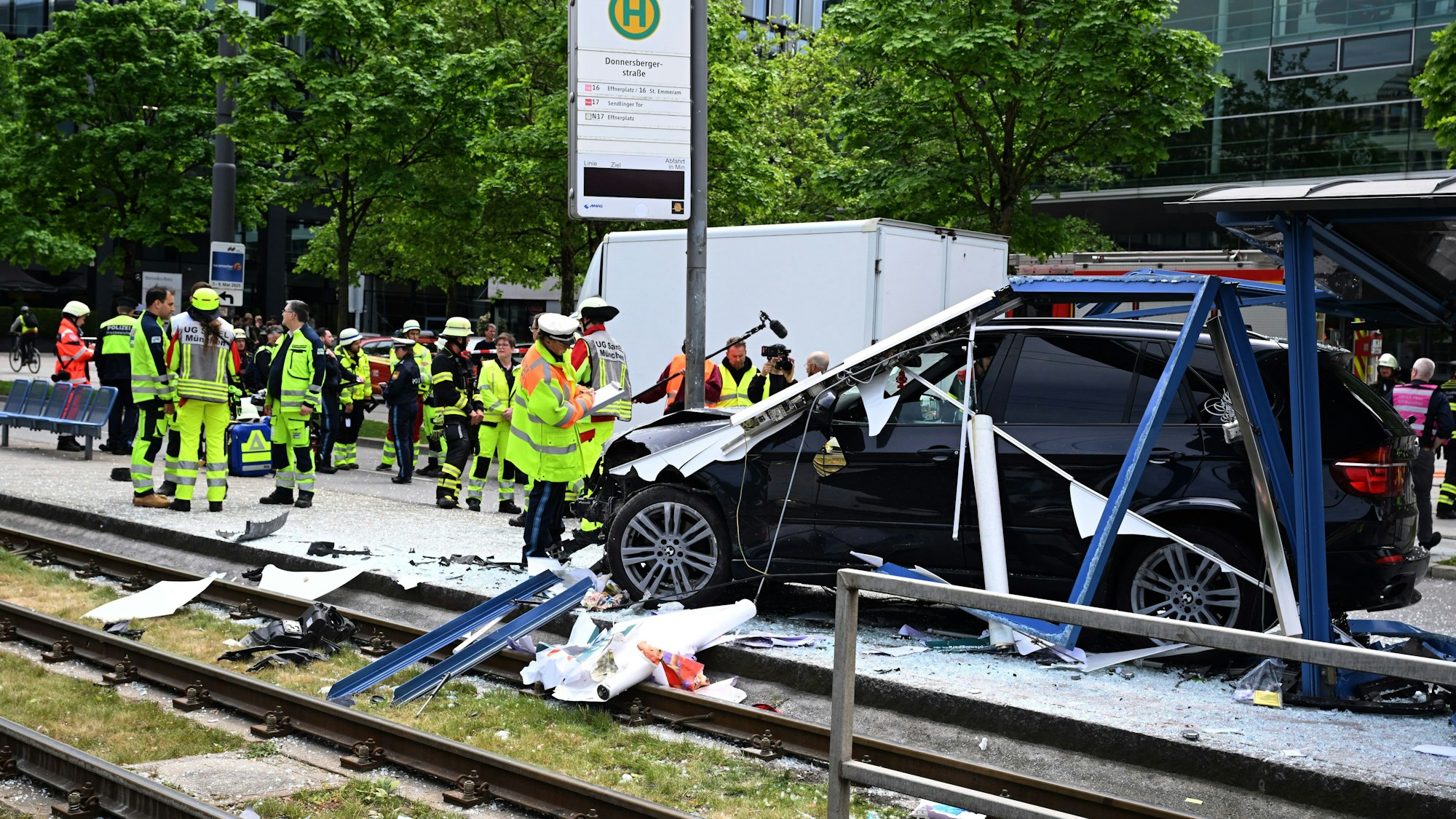 Nach einem Unfall mit einem SUV in München stehen die Einsatzkräfte um die Unglücksstelle.