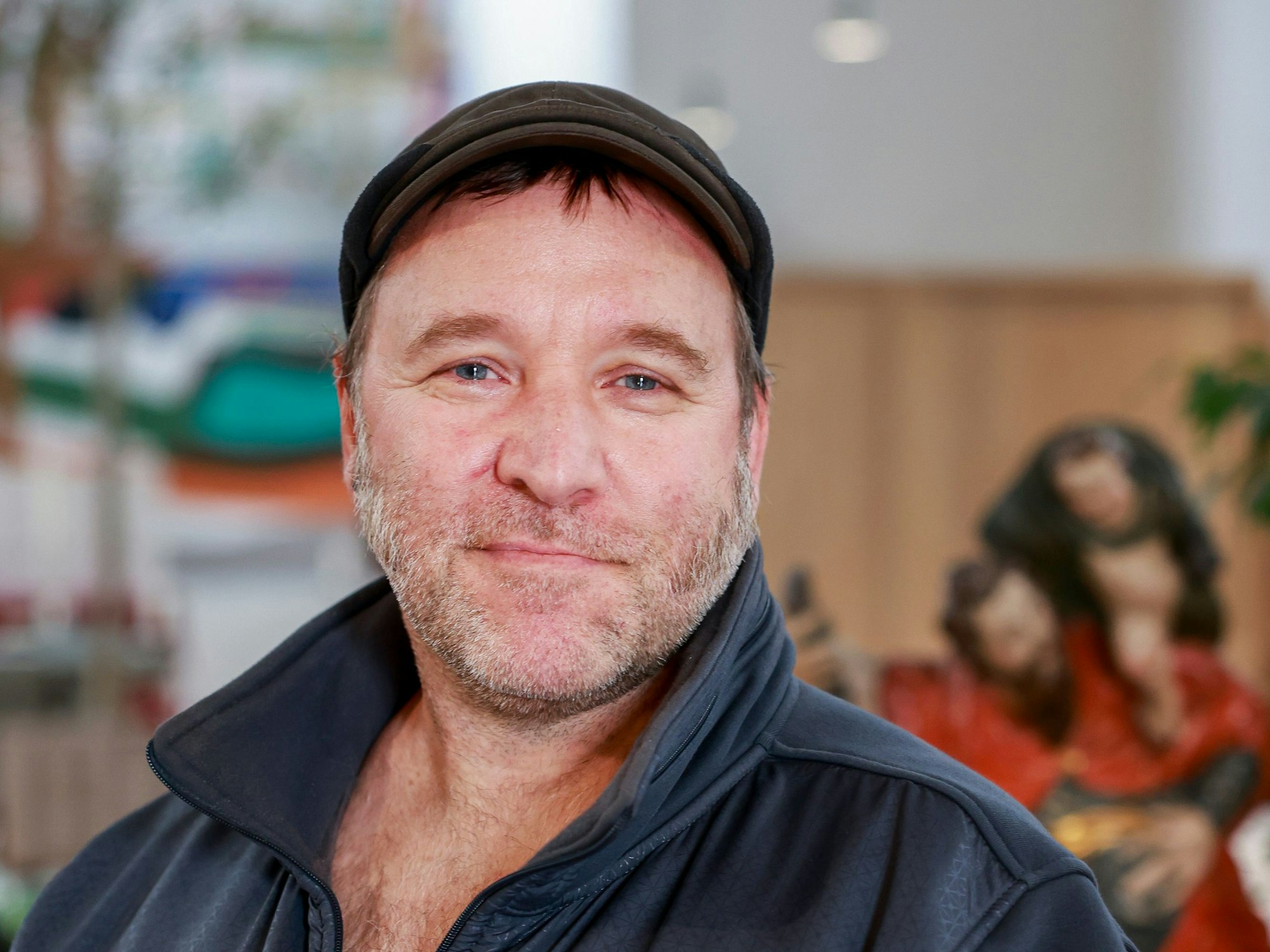 Sascha ist im Porträt zu sehen, er trägt eine Schirmmütze und eine dunkle Jacke.