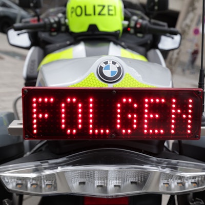 Auf einem Display am Heck eines Polizeimotorrads ist das Wort «Folgen» zu lesen.