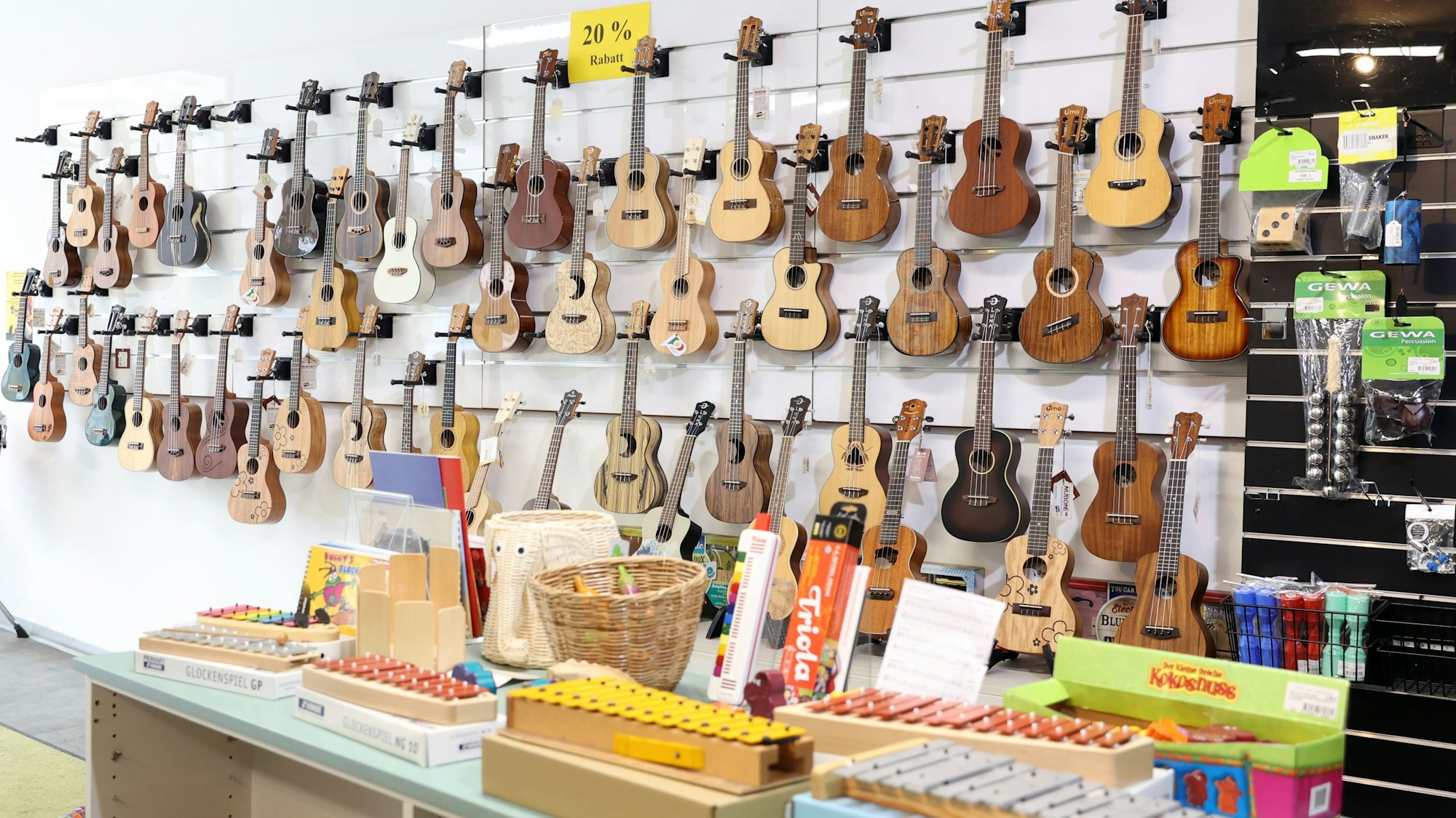 Im Inneren des Musikhauses sind einige Gitarren an einer Wand ausgestellt.