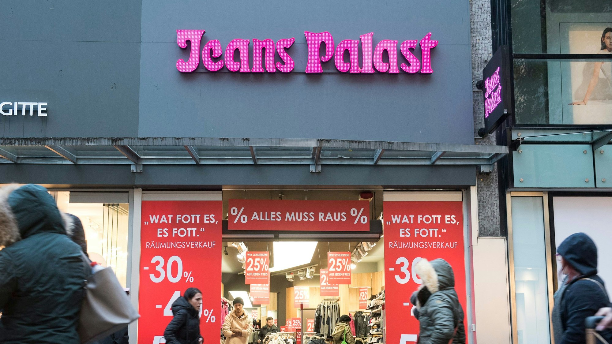 Die Aufnahme des Jeans Palast in der Schildergasse zeigt Schilder, die auf einen Räumgsverkauf im Geschäft hinweisen.