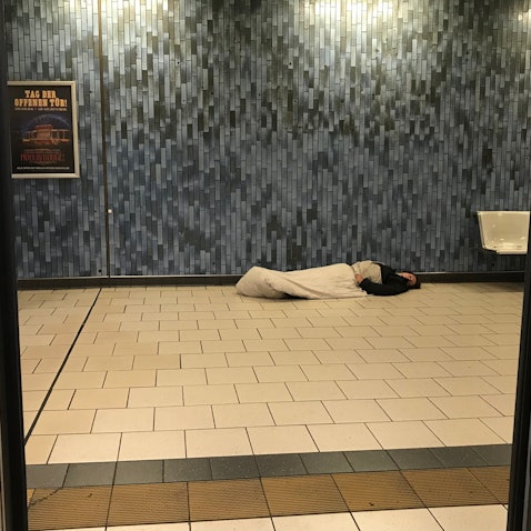 Das Bild zeigt einen schlafenden Obdachlosen im Kölner Hauptbahnhof