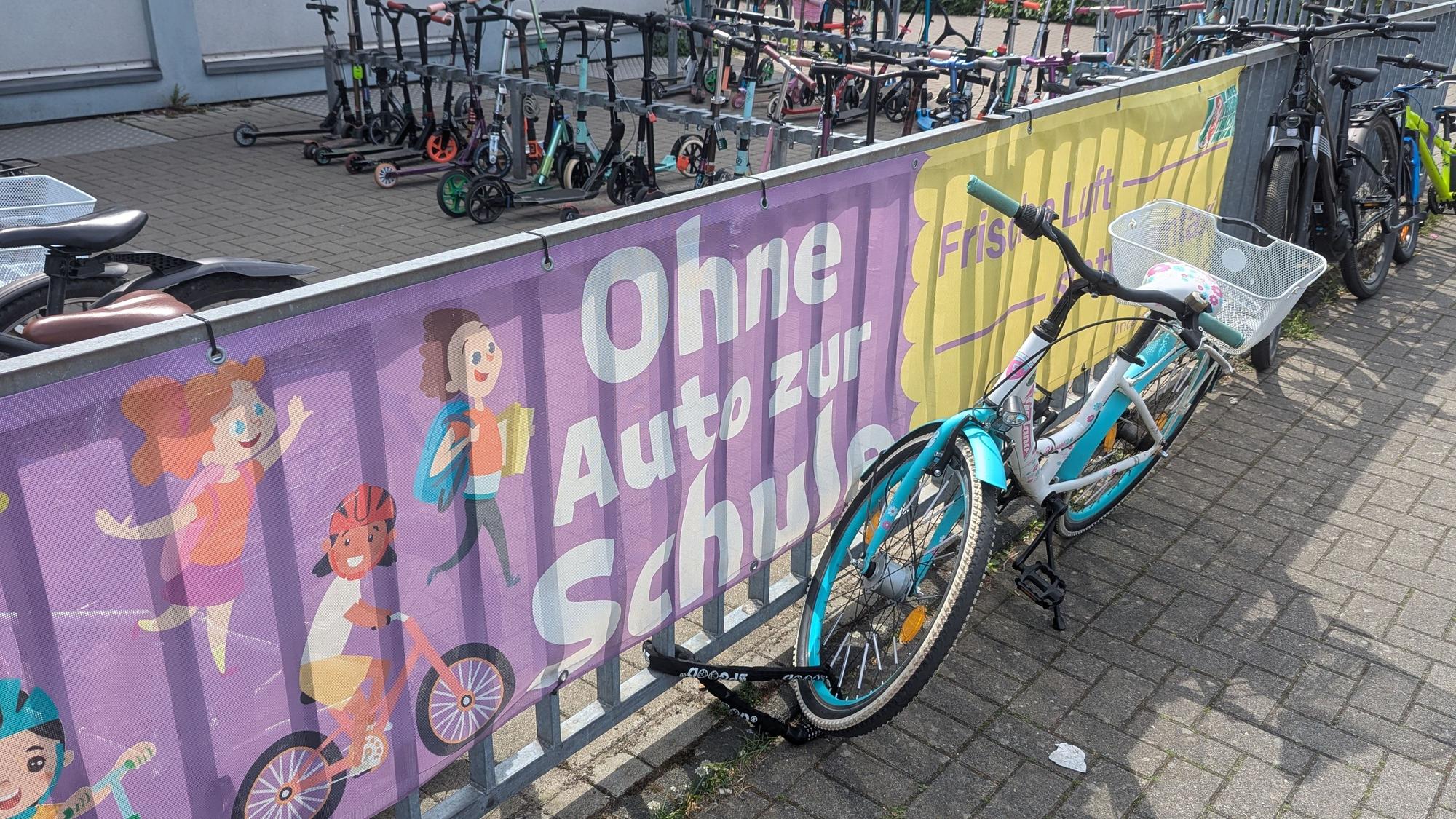Das Foto zeigt ein Banner am Zaun des Fahrradabstellplatzes der Grundschule.