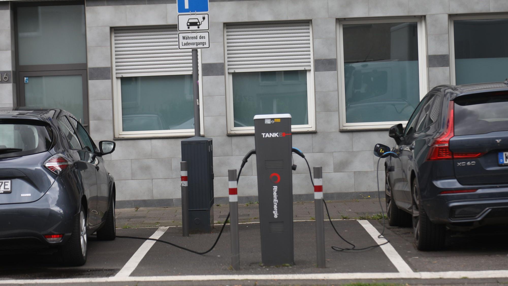 25.07.2024, Köln: Zwei E-Autos stehen an der Merheimer Straße um die Batterie an einer Ladestation aufzuladen. Es gibt noch immer vergleichsweise wenige Ladesäulen für Elektroautos in Köln. Foto: Arton Krasniqi