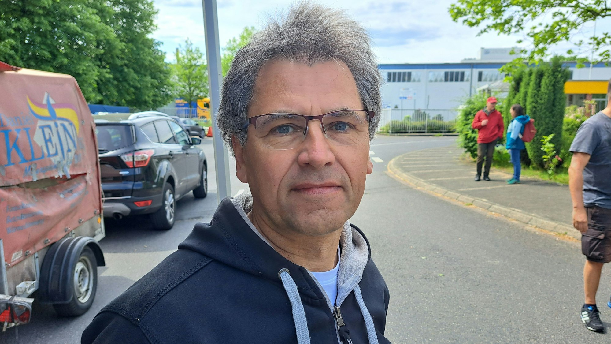 Klaus Hembach steht vor dem Werkstor von Isover in Bergisch Gladbach.