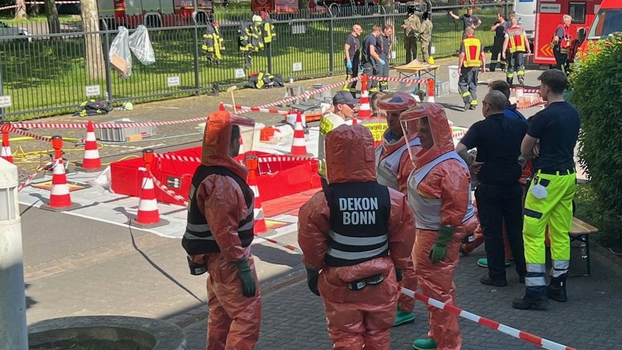 Feuerwehrkräfte in Schutzausrüstung bei einem Großeinsatz nach Fund einer verdächtigen Briefsendung in einer Poststelle in Bonn-Hochkreuz.