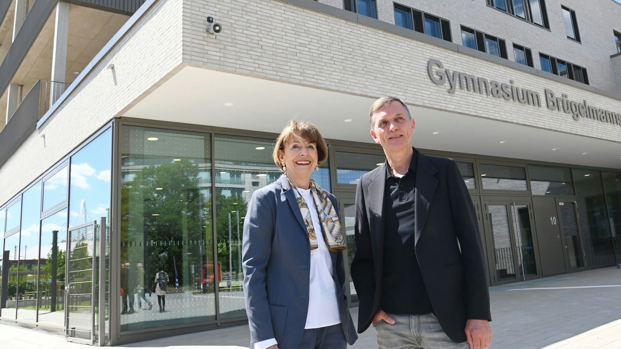 Investor Ulrich Beckmann (r.) baute das Gymnasium nach den Anforderungen der Stadt: Oberbürgermeisterin Henriette Reker bilanziert zur Fertigstellung, wie der Schulneubau insgesamt in Köln vorankommt.