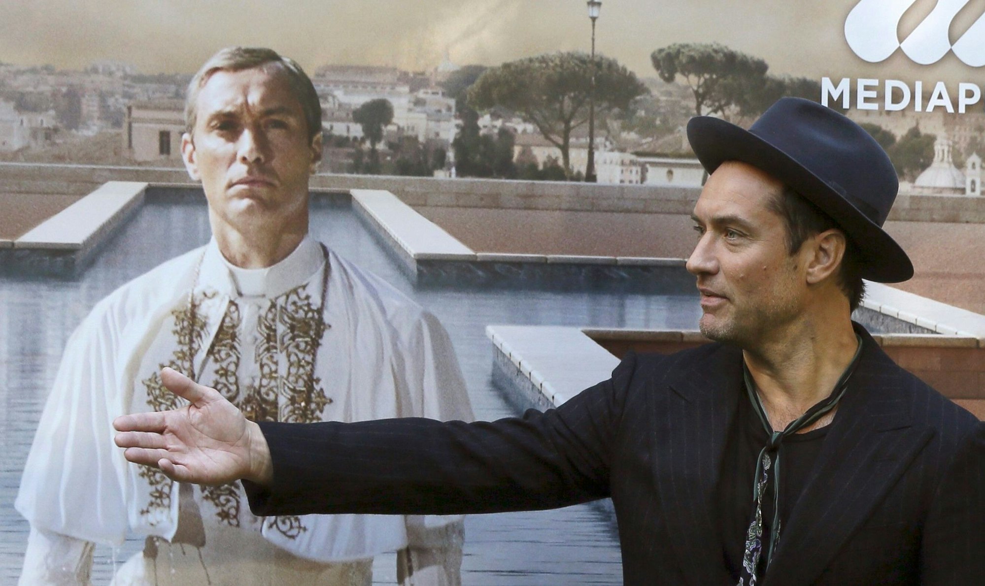 Jude Law vor einem Plakat mit sich als Papst Pius XIII. in der Serie «The Young Pope». (Archivbild)