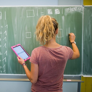 Eine Lehrerin schreibt an eine Schultafel im Mathematikunterricht.