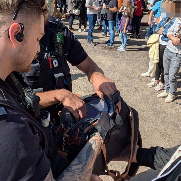 Zwei Polizisten führen auf der Kirmes in Euskirchen Kontrollen durch. Sie schauen in eine Handtasche.