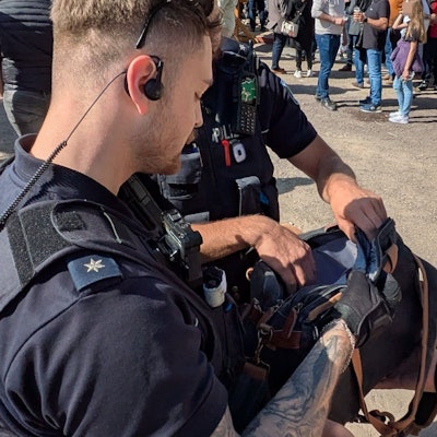 Zwei Polizisten führen auf der Kirmes in Euskirchen Kontrollen durch. Sie schauen in eine Handtasche.