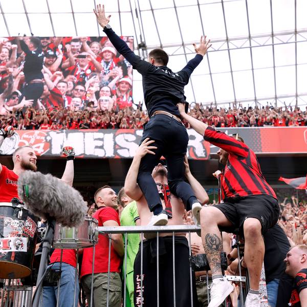 Das Bild zeigt Xabi Alonso nach der Meisterschaft 2024 auf dem Zaun in der Nordkurve der Bay-Arena.