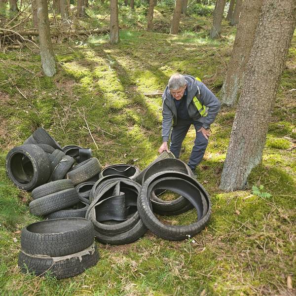 Harald Heinen beugt sich über die Reifen.