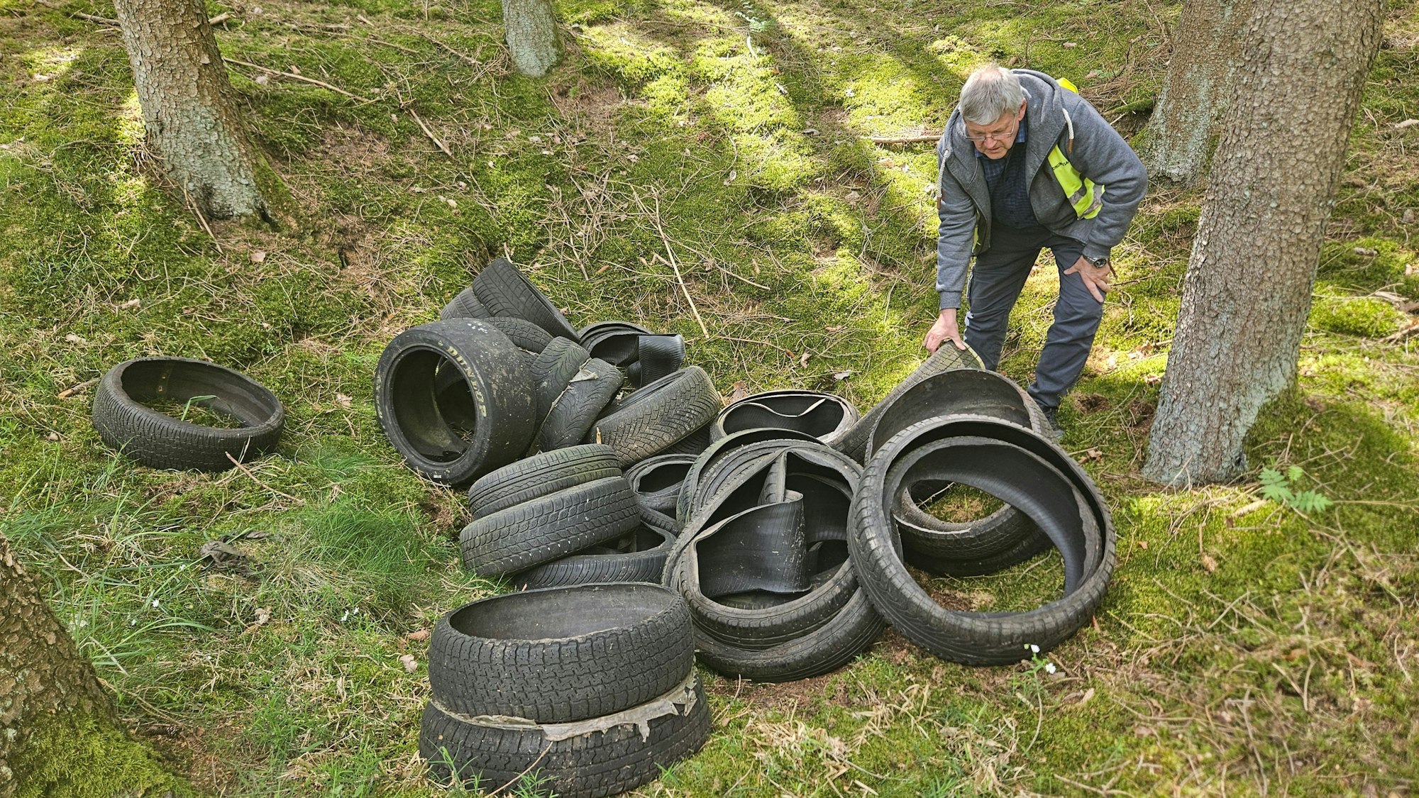 Harald Heinen beugt sich über die Reifen.