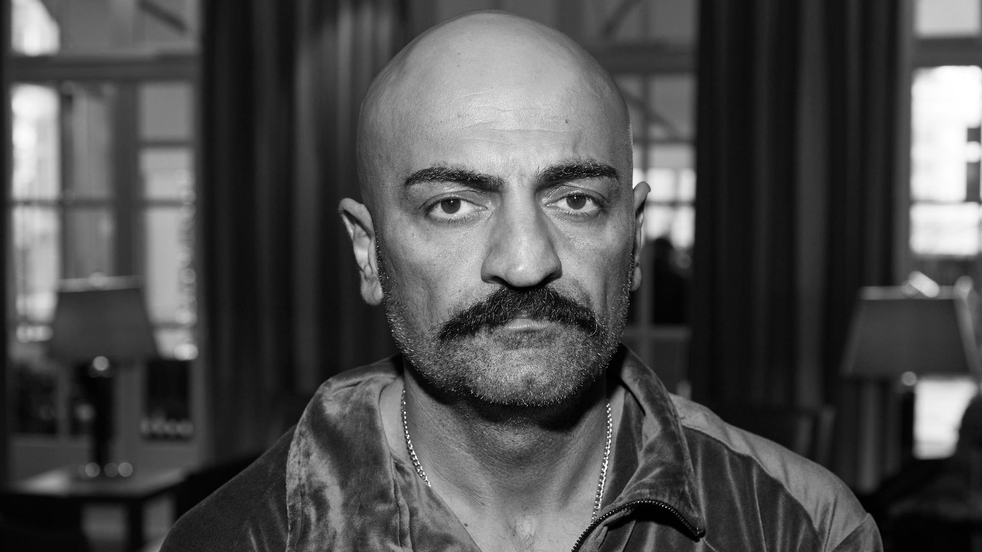 ARCHIV - 01.10.2022, Hamburg: Giwar Hajabi alias Xatar steht im Foyer eines Hotels. Hajabis Film «Rheingold» wurde im Rahmen des 30. Filmfests Hamburg im Cinemaxx vorgeführt. (zu dpa: «Wahre Deutschrap-Legende» - Rapper Xatar tot aufgefunden») Foto: Georg Wendt/dpa +++ dpa-Bildfunk +++