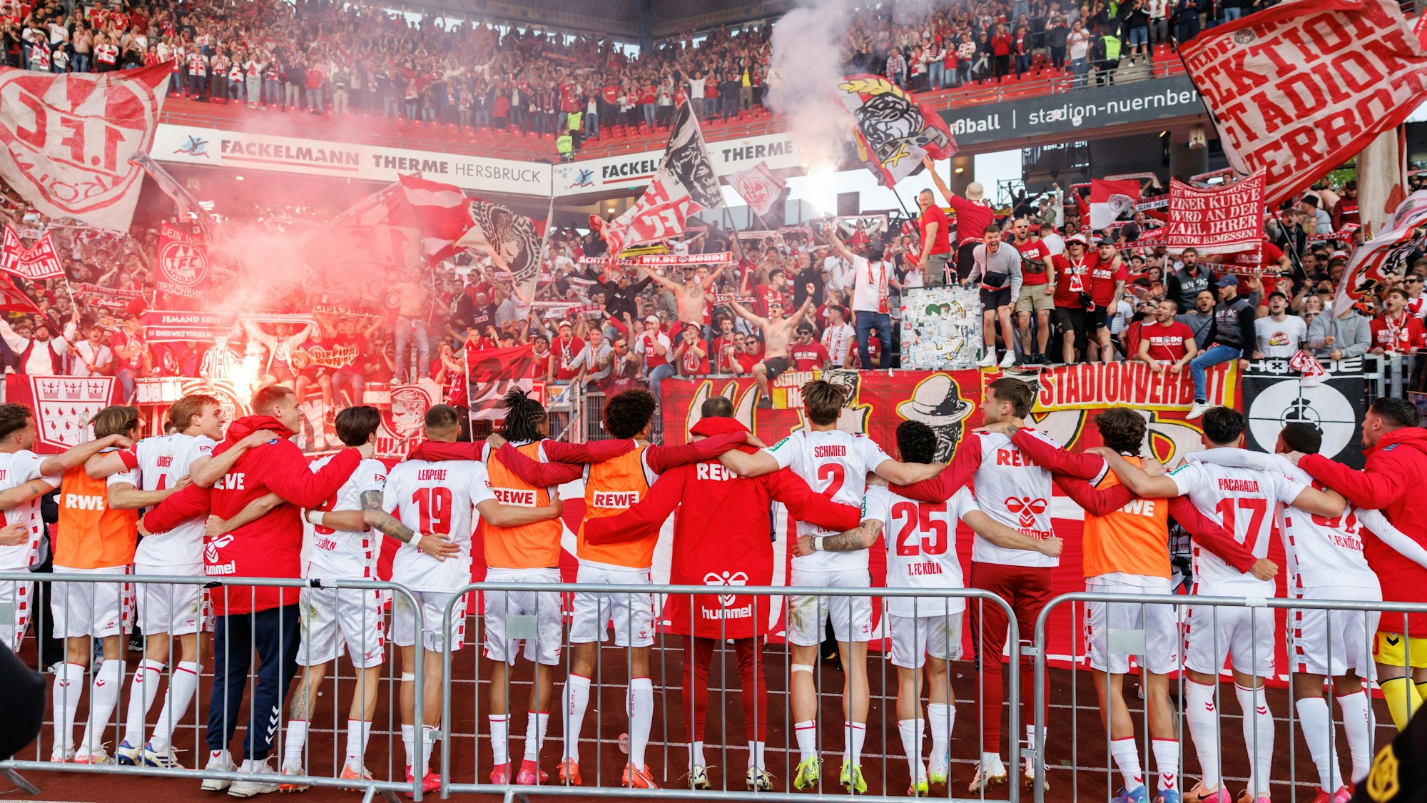 09.05.2025, Bayern, Nürnberg: Fußball: 2. Bundesliga, 1. FC Nürnberg - 1. FC Köln, 33. Spieltag im Max-Morlock-Stadion. Die Kölner Spieler jubeln über ihren Sieg nach dem Abpfiff vor der Fankurve. Foto: Daniel Karmann/dpa - WICHTIGER HINWEIS: Gemäß den Vorgaben der DFL Deutsche Fußball Liga bzw. des DFB Deutscher Fußball-Bund ist es untersagt, in dem Stadion und/oder vom Spiel angefertigte Fotoaufnahmen in Form von Sequenzbildern und/oder videoähnlichen Fotostrecken zu verwerten bzw. verwerten zu lassen. +++ dpa-Bildfunk +++