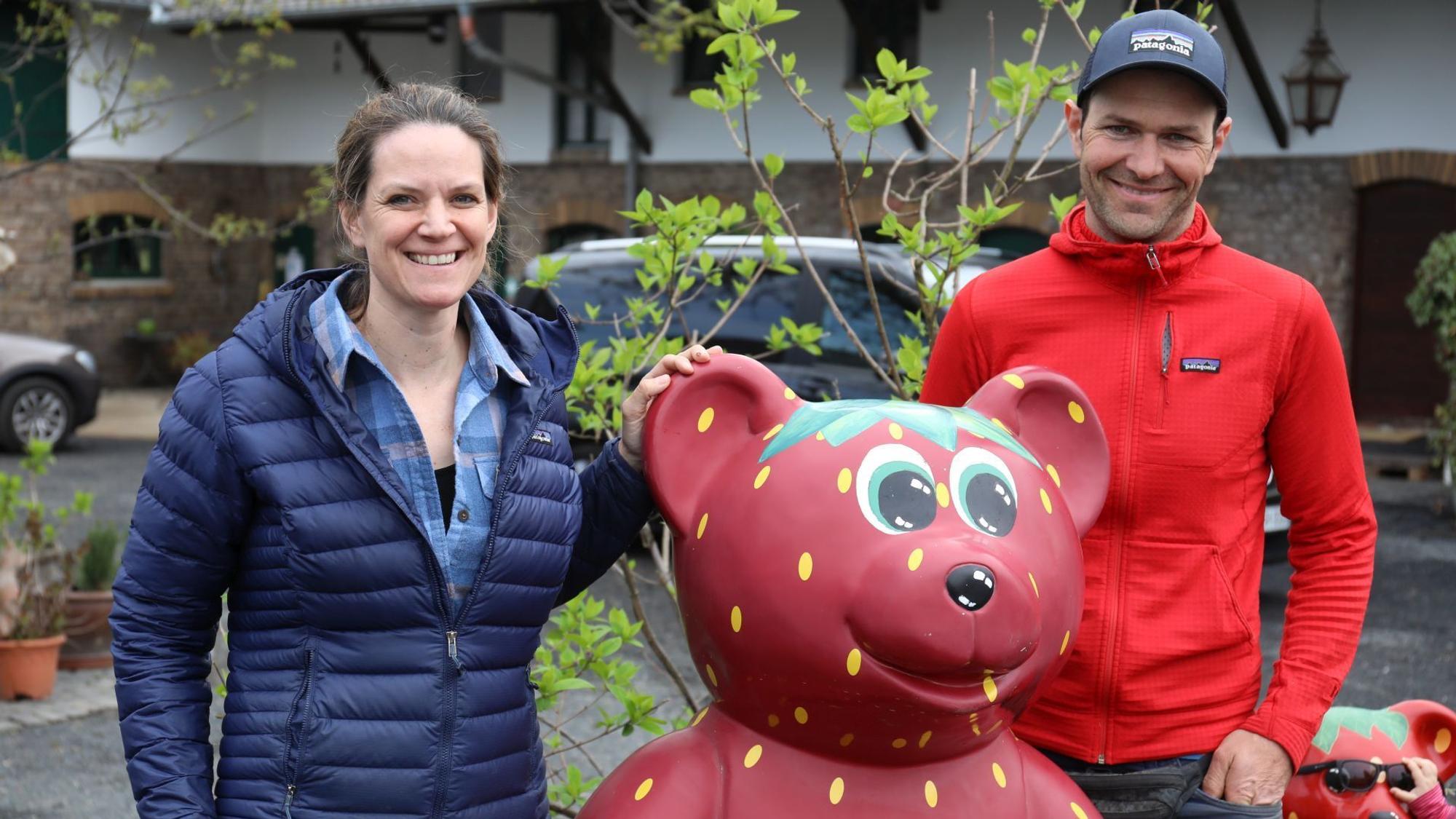 Ein Mann und eine Frau mit einer roten Bärenfigur.