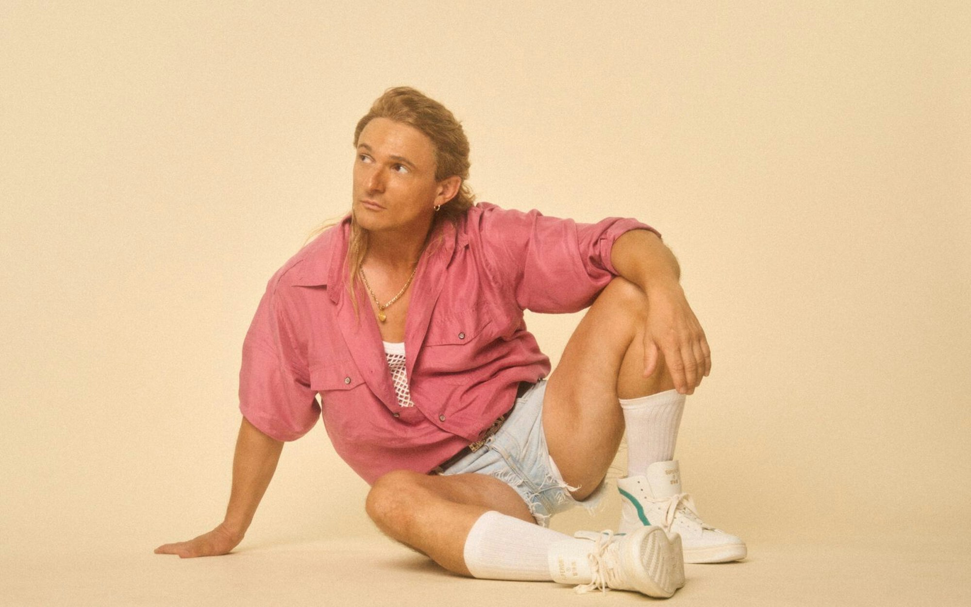 Die sehenswerte und mit viel 90-er-Jahre-Flair versehene Comedy „Messiah Superstar“: Florian Lukas spielt einen vergessenen Euro-Dance-Sänger. In Szenen von früher sieht man ihn mit Wallemähne als exzentrischen Popstar. (Bild: Joyn / Thomas Mikule)