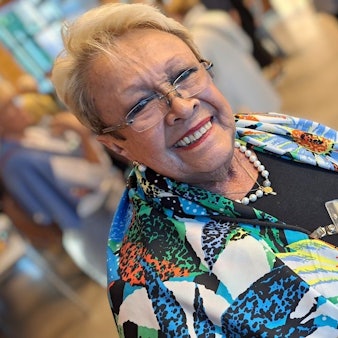 Ana Maria Preußer schaut von ihrem Handy auf, auf dem ein Foto des neuen Papstes als Augustinermönch zu sehen ist.