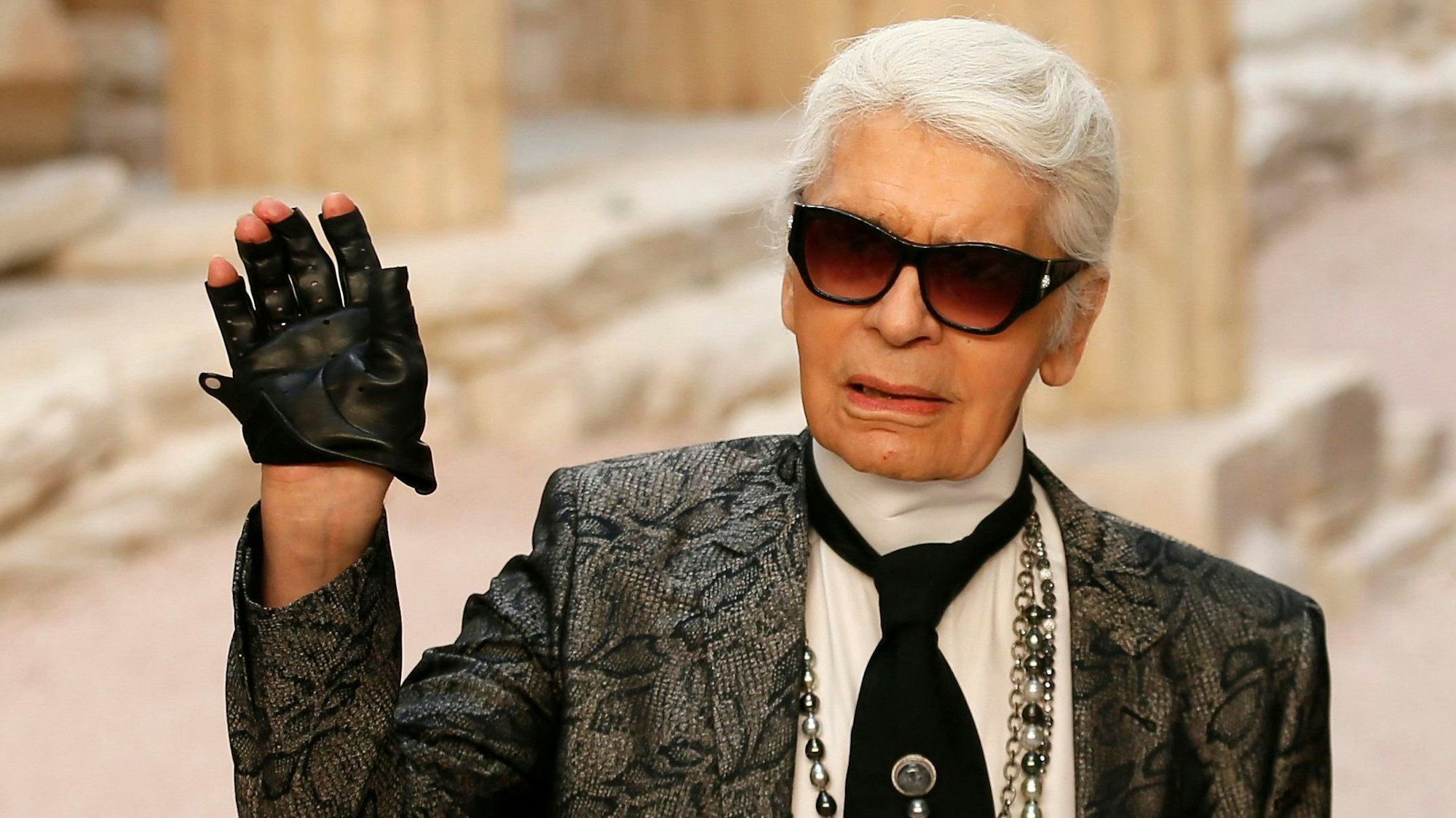 Der Modedesigner Karl Lagerfeld winkt bei der Präsentation einer Chanel-Damen-Kollektion.