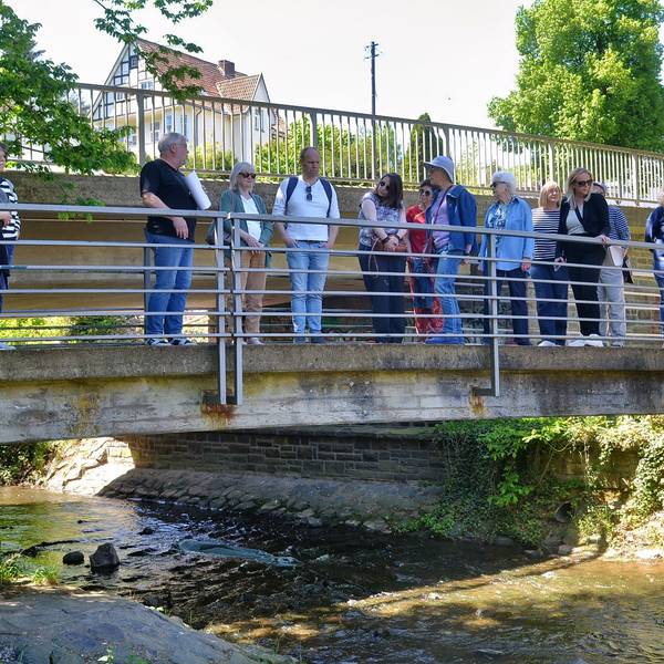 Eine Gruppe von Personen steht auf einer Brücke über die Erft in Bad Münstereifel.
