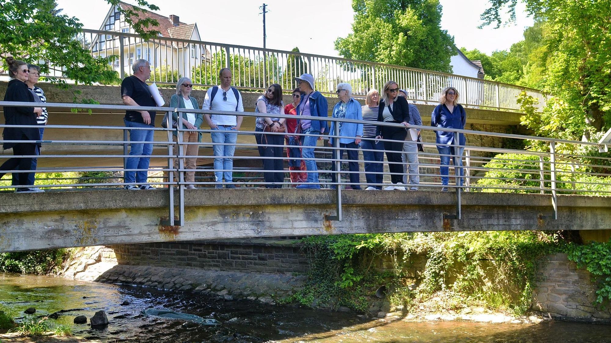 Eine Gruppe von Personen steht auf einer Brücke über die Erft in Bad Münstereifel.