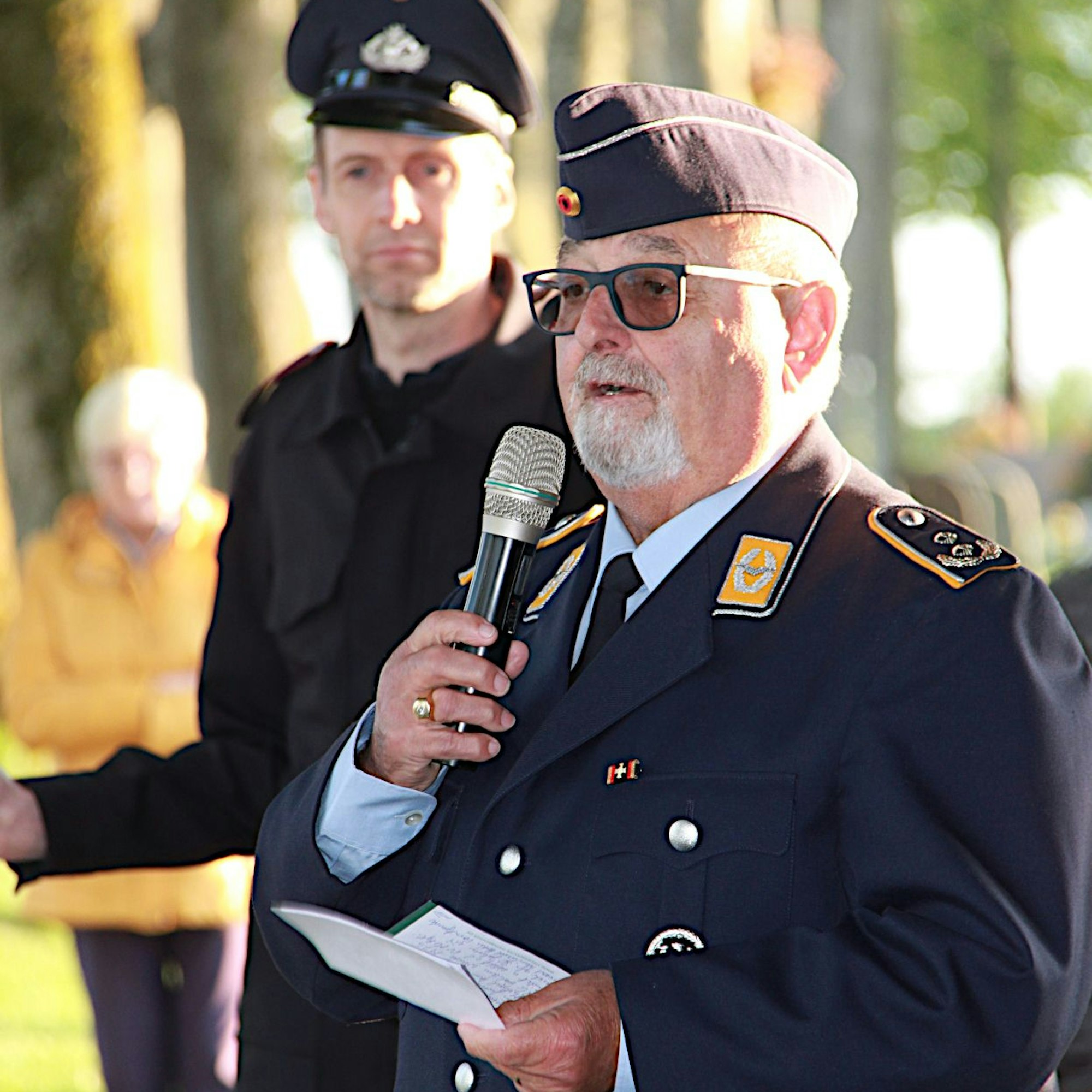 Hans Kurt Schmitt, Vorstand der Kreisgruppe Eifel der Reservistenkameradschaft der Bundeswehr (Gerolstein), bei einer Ansprache in Dahlem. Er trägt eine dunkelblaue Bundeswehr-Uniform.