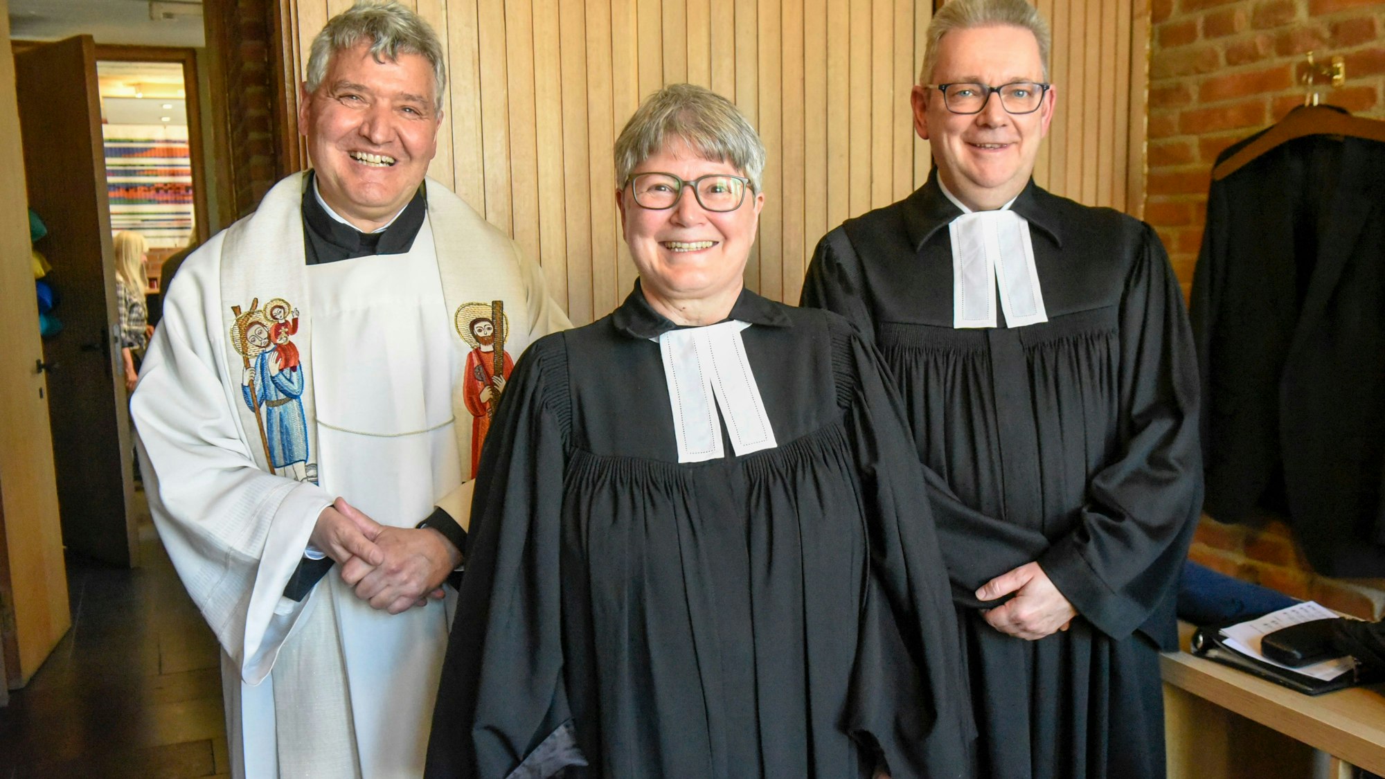 Die Pfarrerin ist im Talar gekleidet.