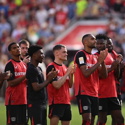 Das Bild zeigt Spieler von Bayer 04 Leverkusen nach dem Spiel gegen Borussia Dortmund, die sich bei den Fans bedanken.
