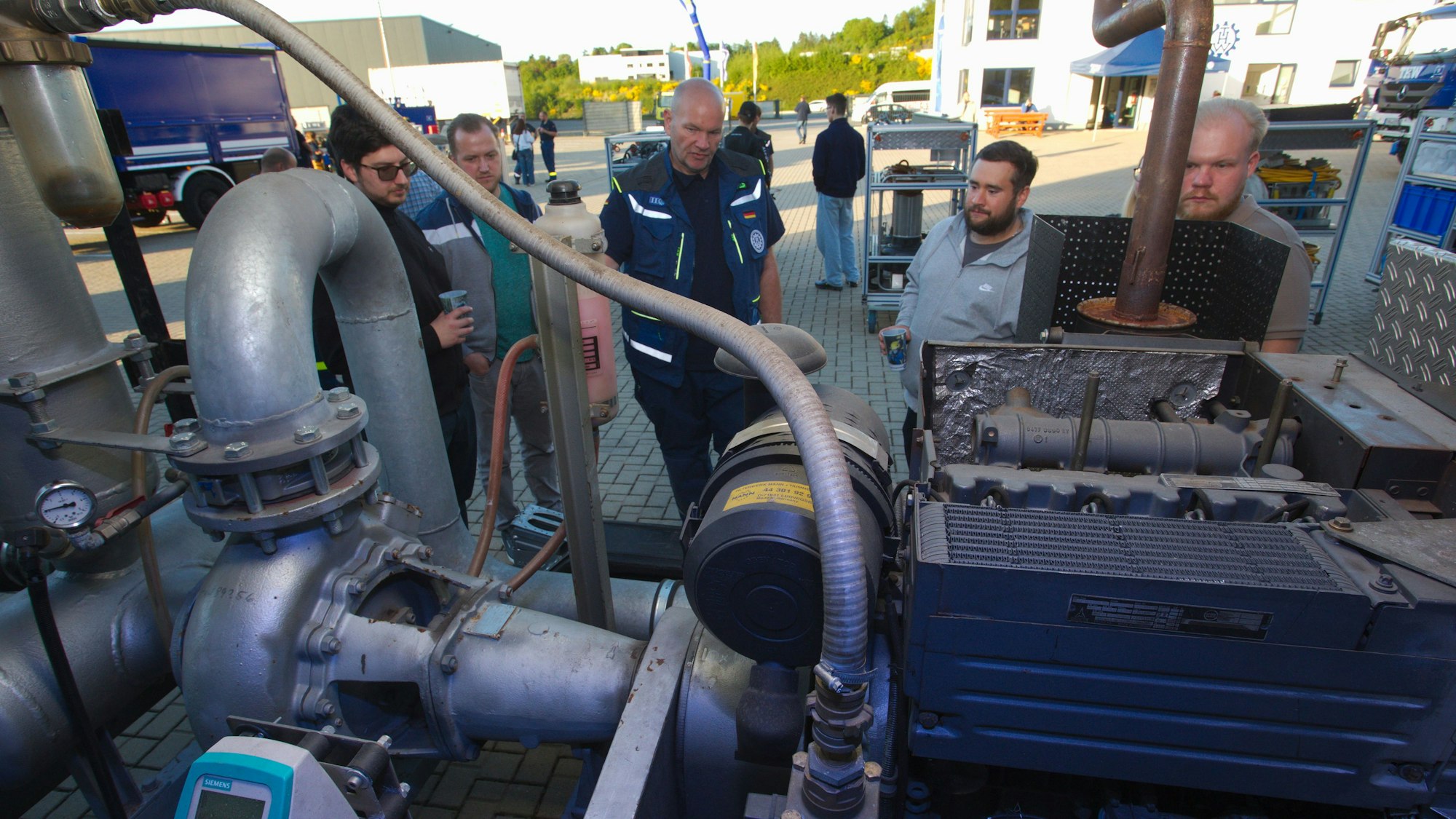 Ein Mitarbeiter des THW erklärt den Interessierten die Schmutzwasserkreiselpumpe "Hannibal"