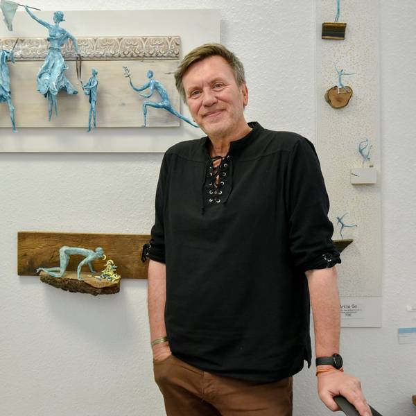 Andre Duront steht vor seinen Skulptren, die dank Magneten an der Wand hängen.