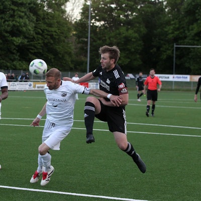 Moritz Hartmann köpft einen Ball, von hintern nähert sich Nierfelds damaliger Kapitän Stephen Kinnen. Bessenichs Ex-Spieler Samson Sayongo beobachtet die Szene erstaunt.