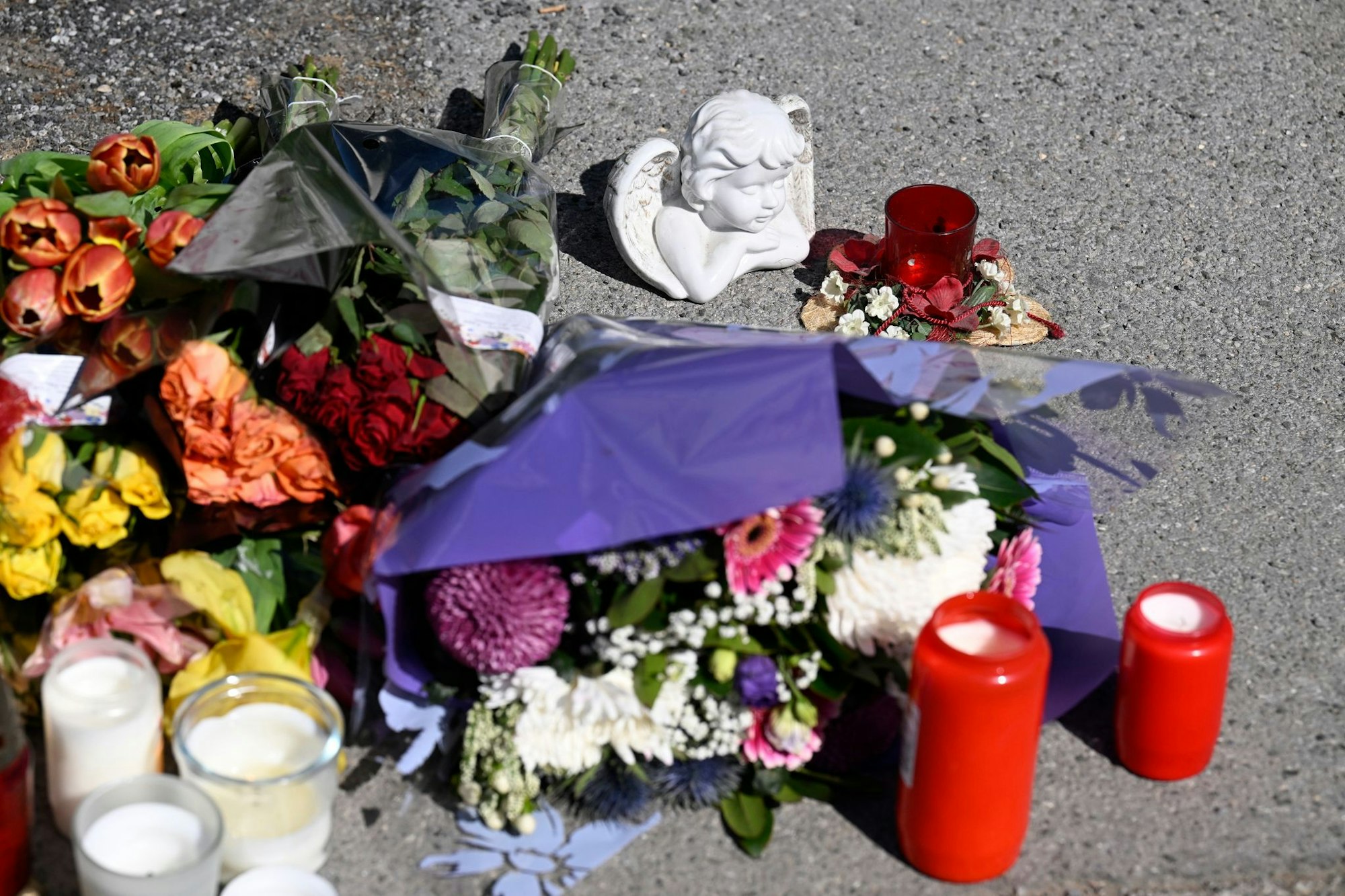 Zeichen der Anteilnahme: Auf einem Bürgersteig an dem Spielplatz sind Kerzen und Blumen niedergelegt worden.