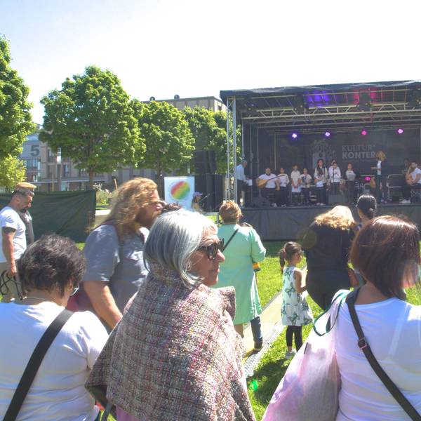 Vor der aufgebauten Bühne im Gummersbacher Stadtgarten, hören Besucher des Festivals dem Chor der anatolischen Stimme zu.