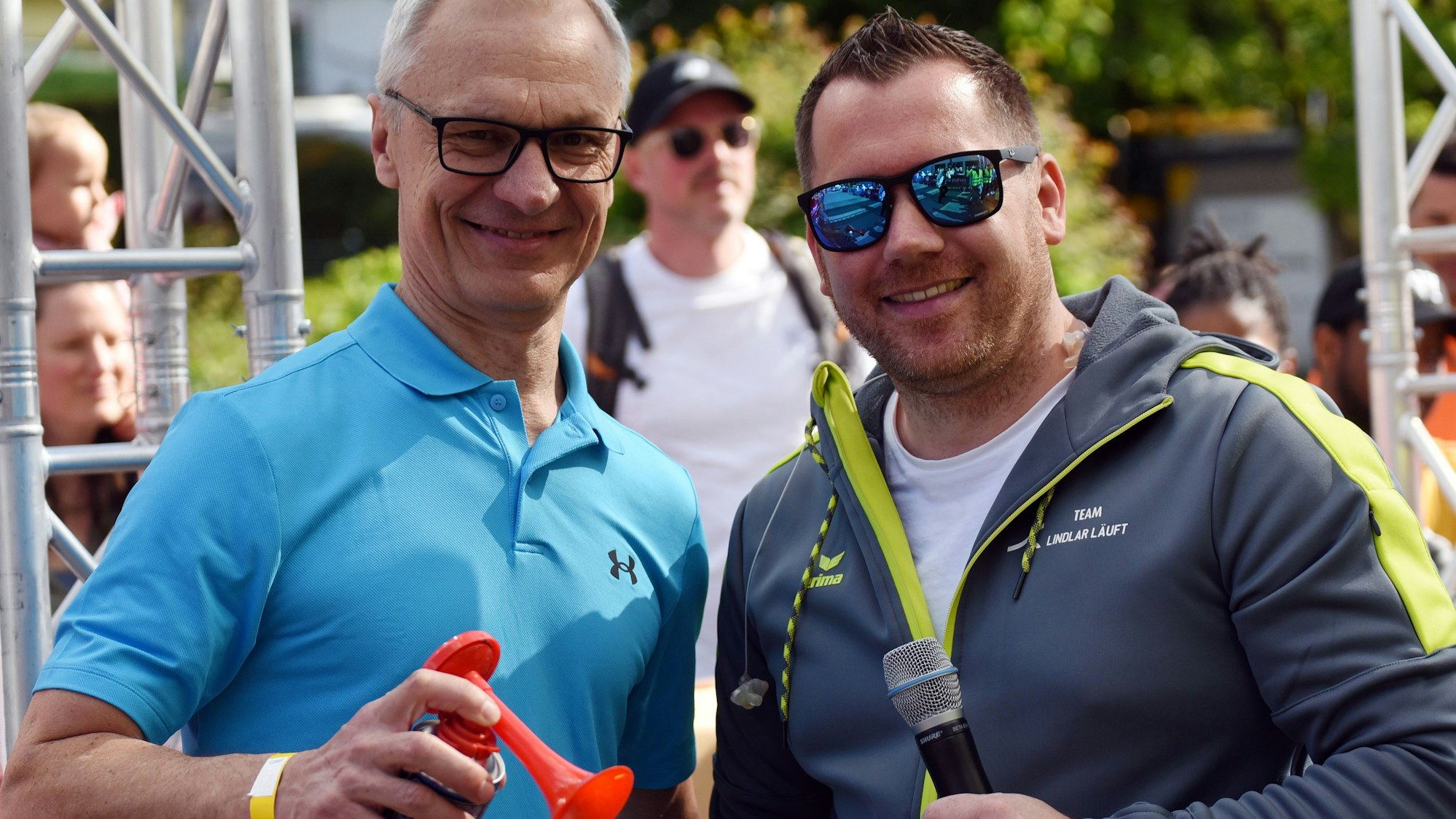 Zwei Männer mit Gas-Tröte sind zu sehen.