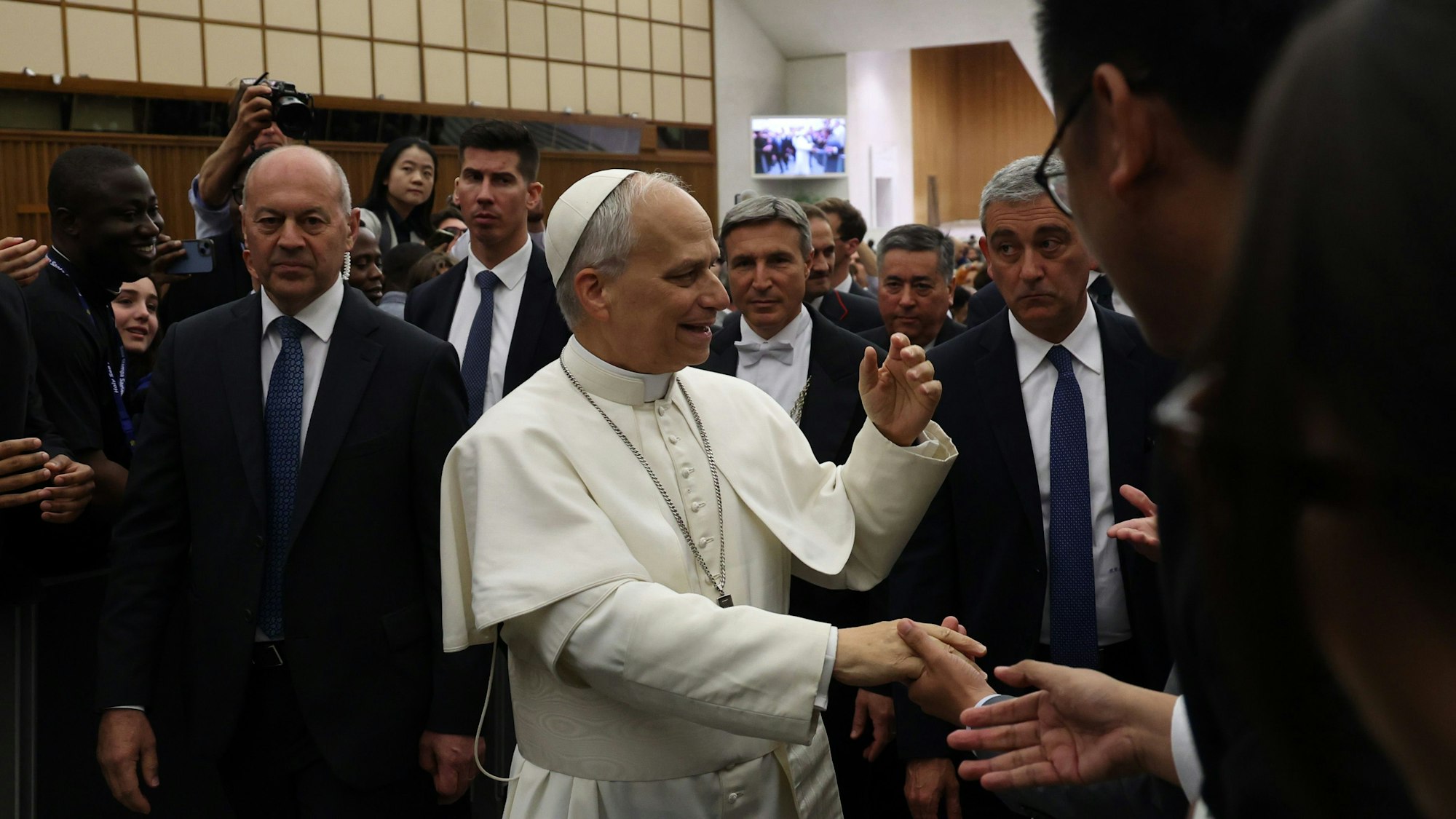 Der neu gewählte Papst schüttelt Medienvertretern im Vatikan die Hände.