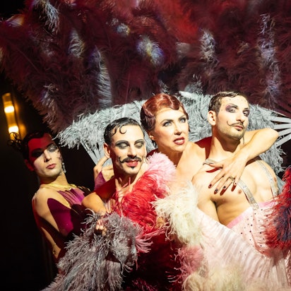 Die Sängerin Annette Dasch inmitten von Tänzern und Pfauenfedern