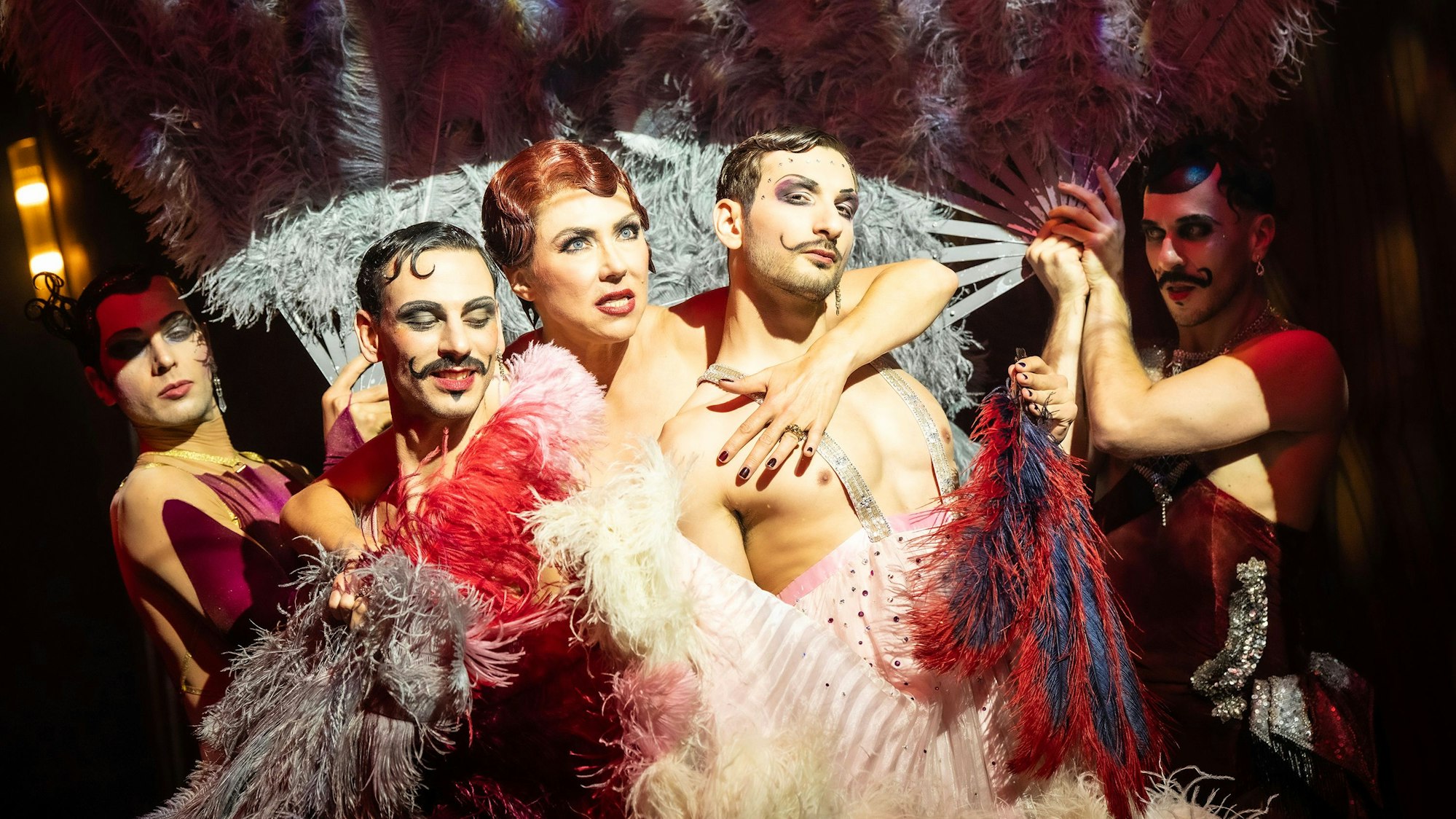 Die Sängerin Annette Dasch inmitten von Tänzern und Pfauenfedern