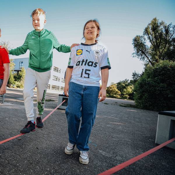 Drei Jugendliche auf einer Slackline