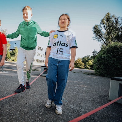 Drei Jugendliche auf einer Slackline