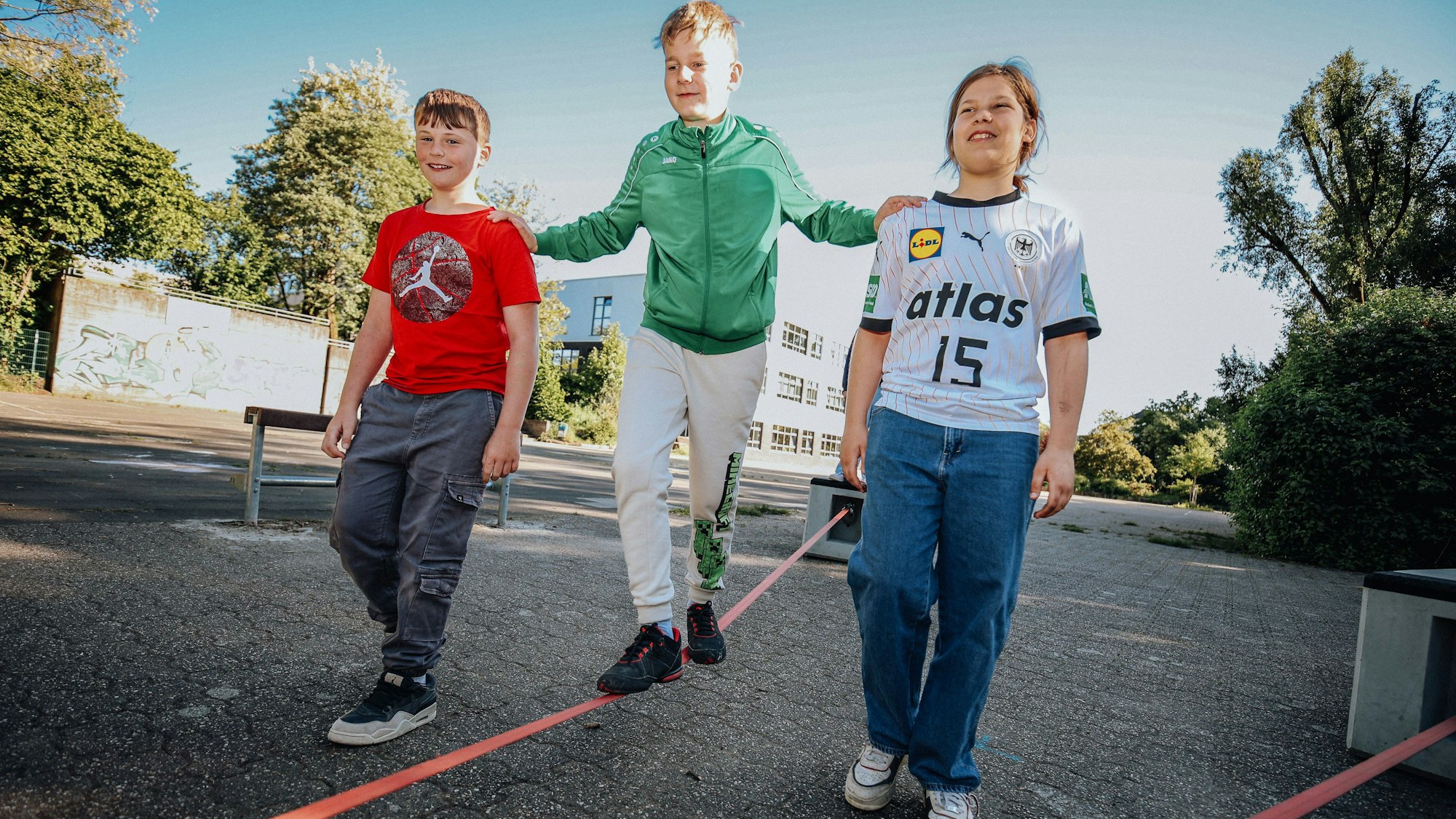 Drei Jugendliche auf einer Slackline