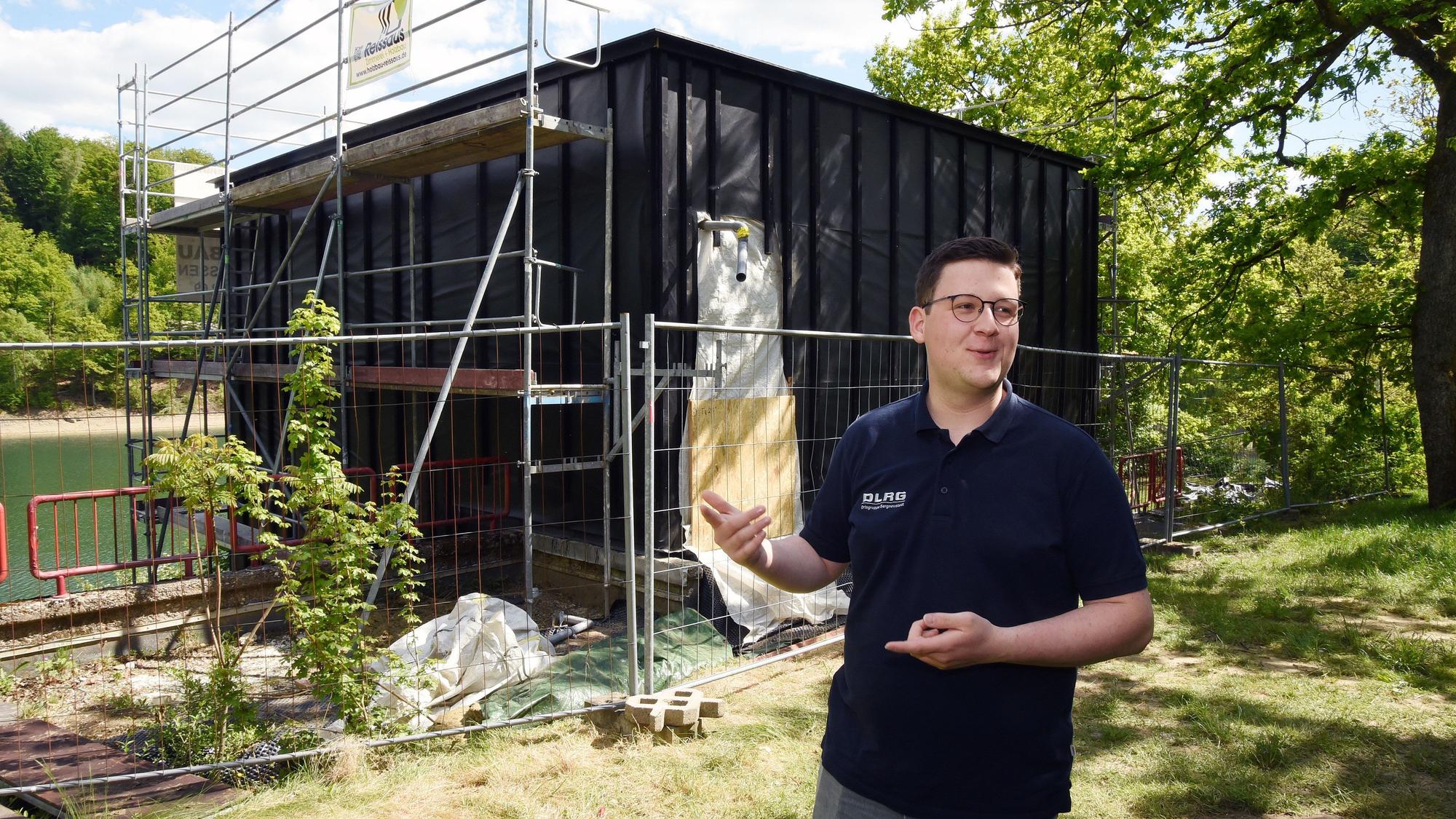 Das Foto zeigt den halbfertigen Neubau der Station, davor steht Philip Solbach von der DLRG.