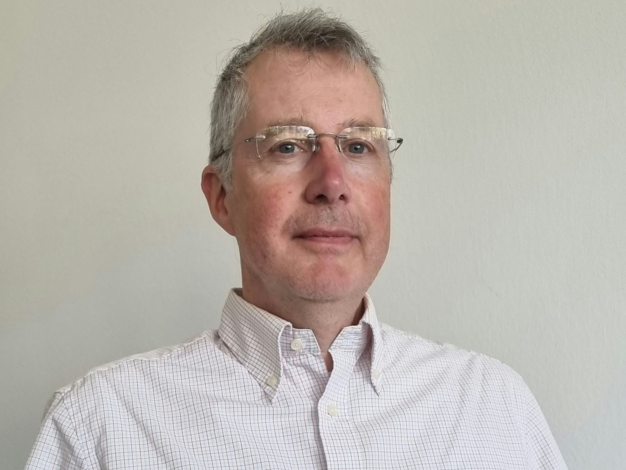 Ein Mann mit Brille und kariertem Hemd.