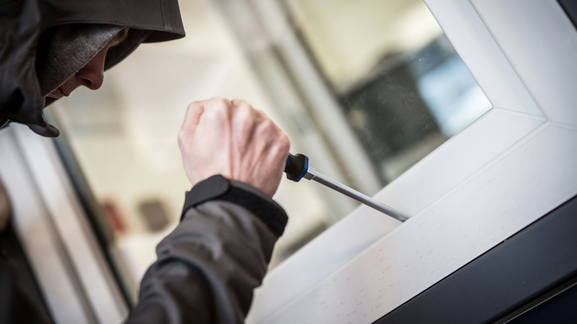 Ein Mann demonstriert in der polizeilichen Beratungsstelle, wie Einbrecher Fenster aufhebeln. (Symbolfoto)