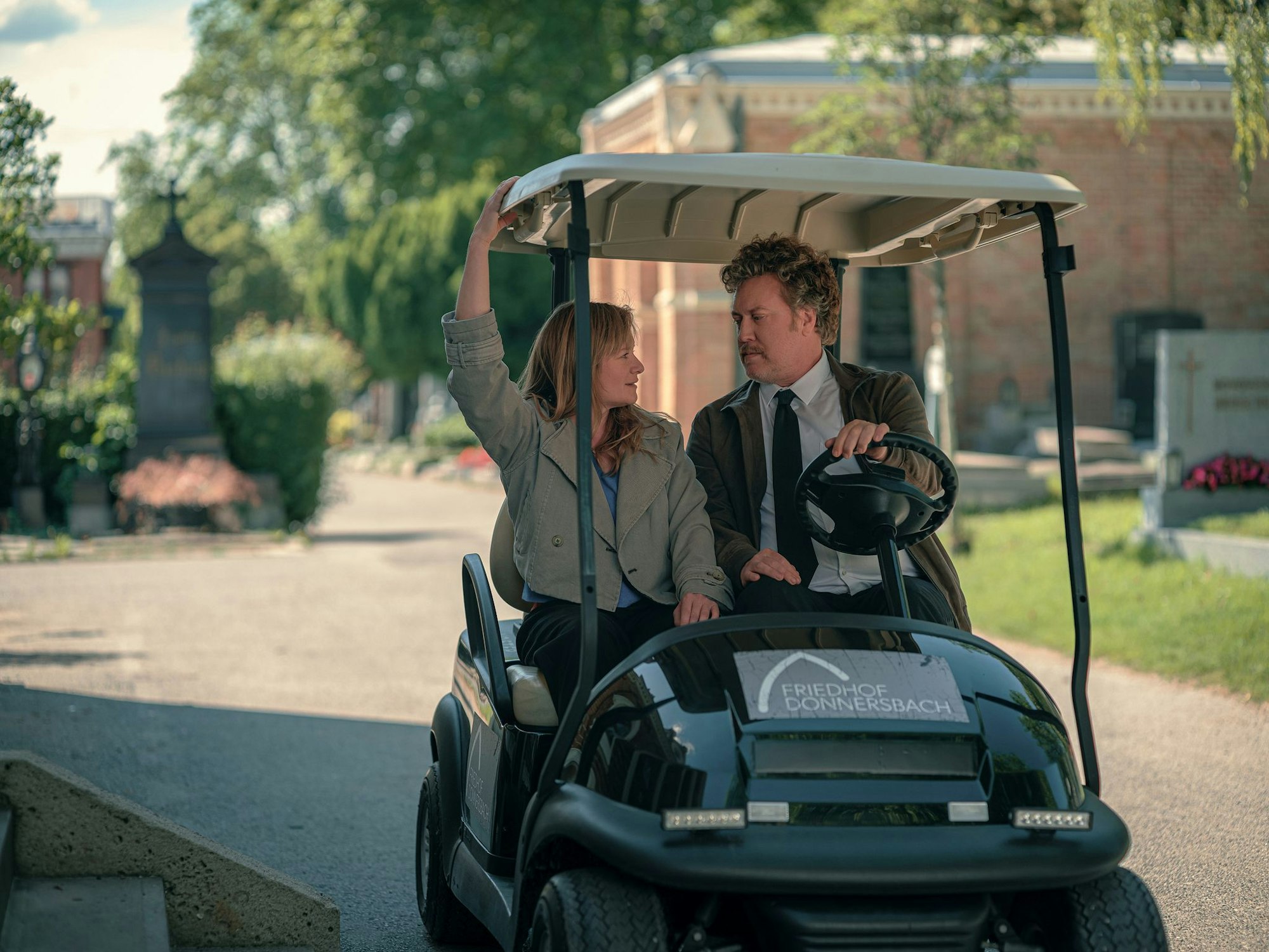 Ursula Fink (Julia Jentsch) und Heli Wondratschek (Nicholas Ofczarek) in einer Szene aus der ersten Staffel der Serie «Drunter und Drüber – Chaos auf dem Friedhof» (Prime Video).