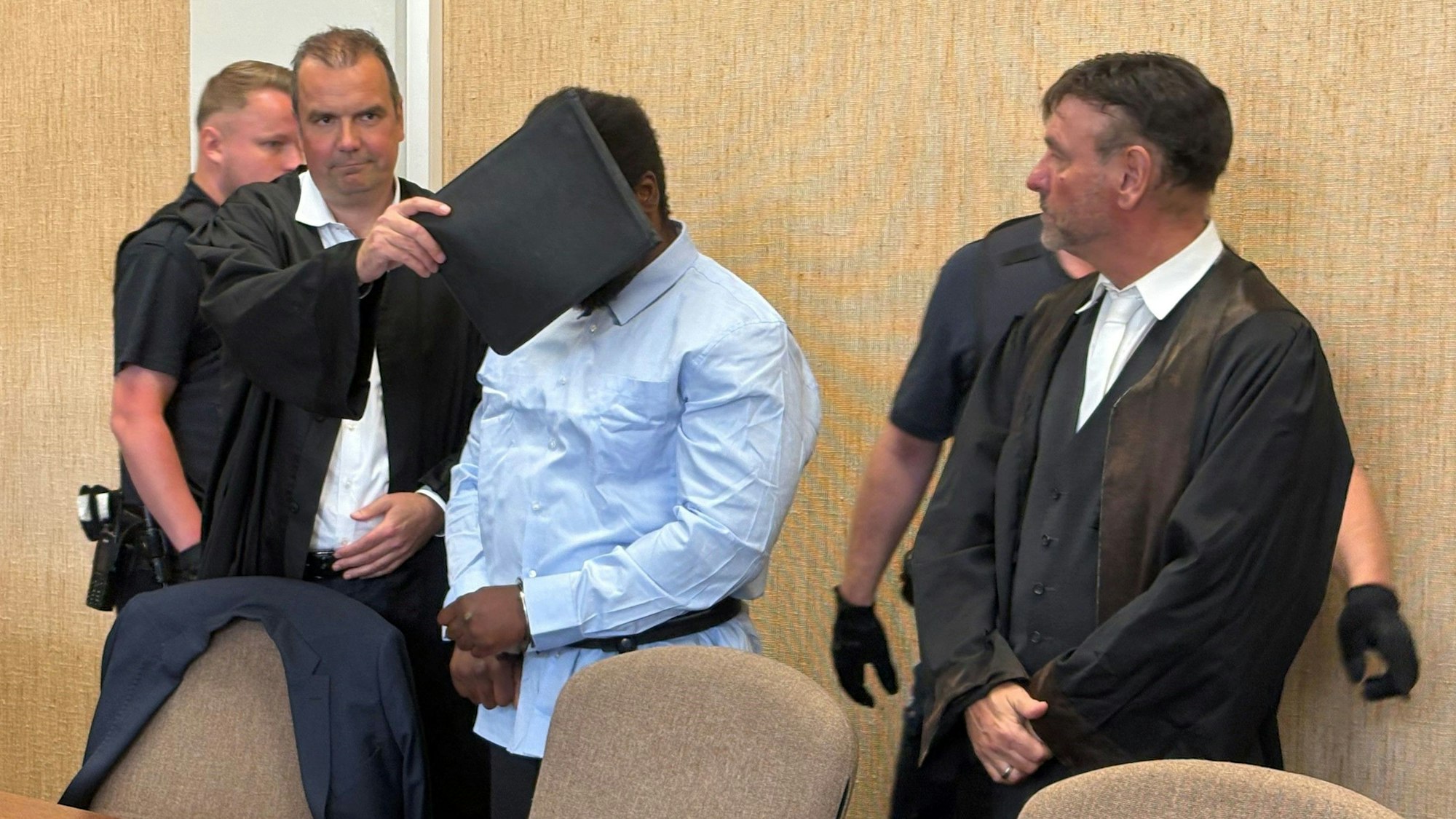 Mai 2025: Der Angeklagte, hier mit seinen Verteidigern, musste Handfesseln tragen.
