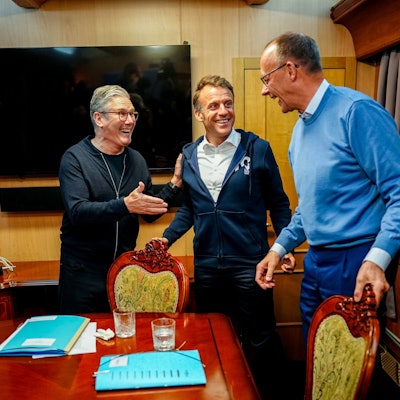 Bundeskanzler Friedrich Merz (r, CDU), Keir Starmer (l), Premierminister von Großbritannien, und Frankreichs Präsident Emmanuel Macron stehen im Salonwagen des Sonderzugs nach Kiew zusammen
