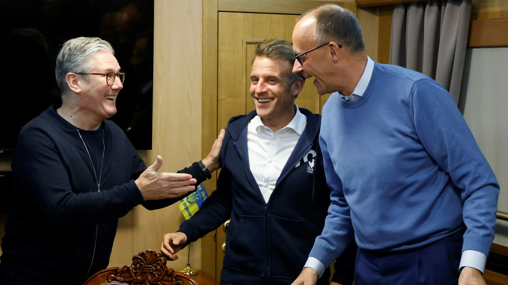 Gute Laune beim britischen Premierminister Keir Starmer (l.), Frankreichs Präsident Emmanuel Macron (M.) und Bundeskanzler Friedrich Merz im Zug auf dem Weg in die Ukraine.