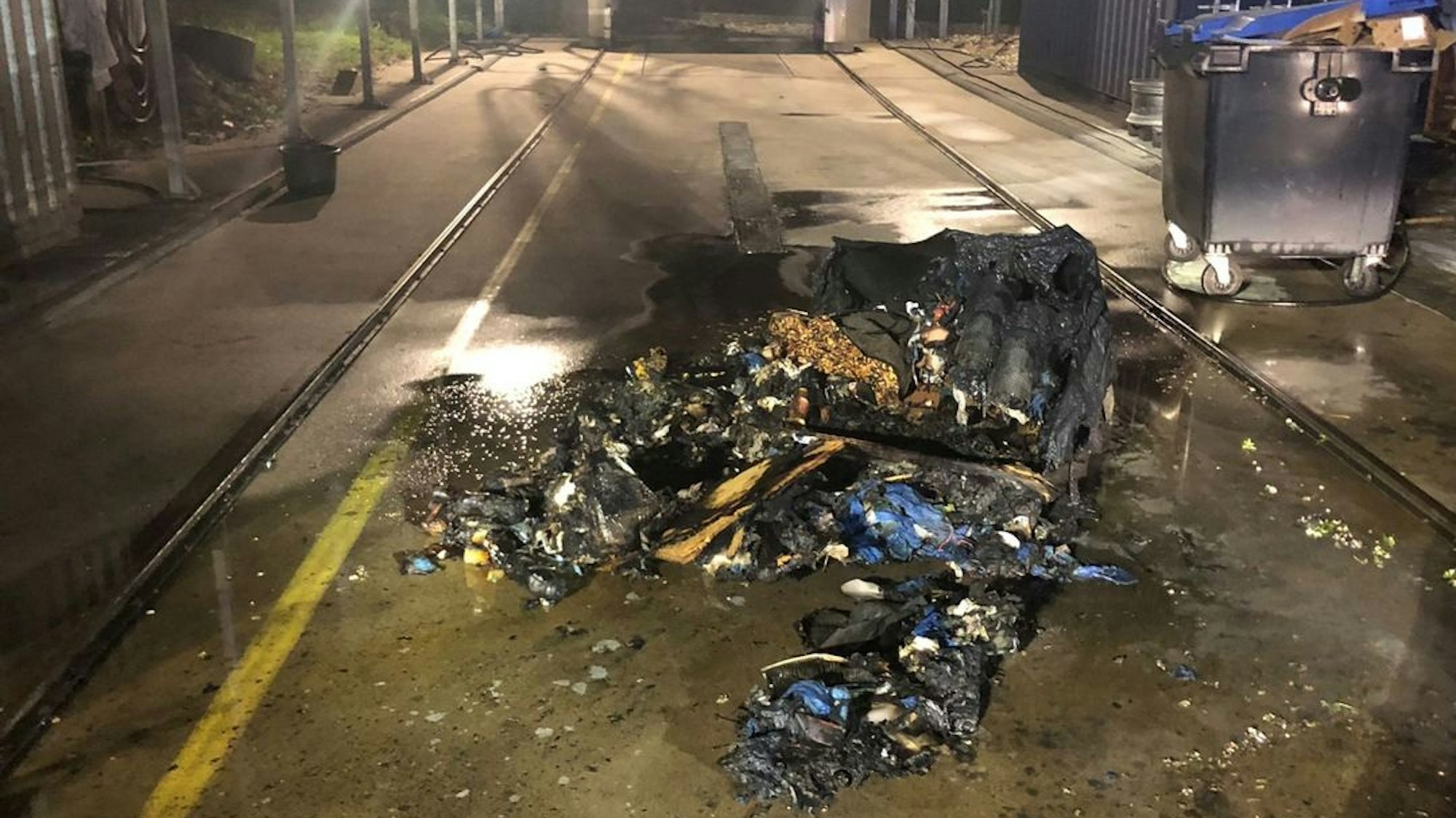 Die Freiwillige Feuerwehr Bedburg-Hau im Einsatz nach einem Brand eines 1100-Liter-Müllcontainers auf einem Speditionsgelände in Hasselt.