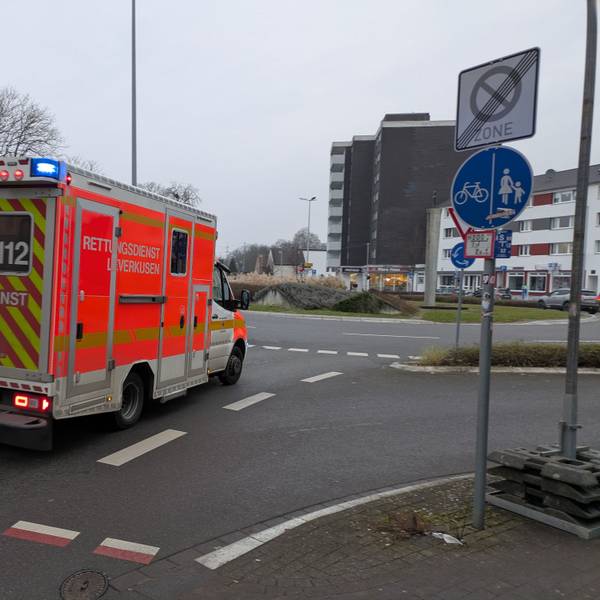 Ein Rettungswagen fährt mit Blaulicht auf den Berliner Platz in Opladen.